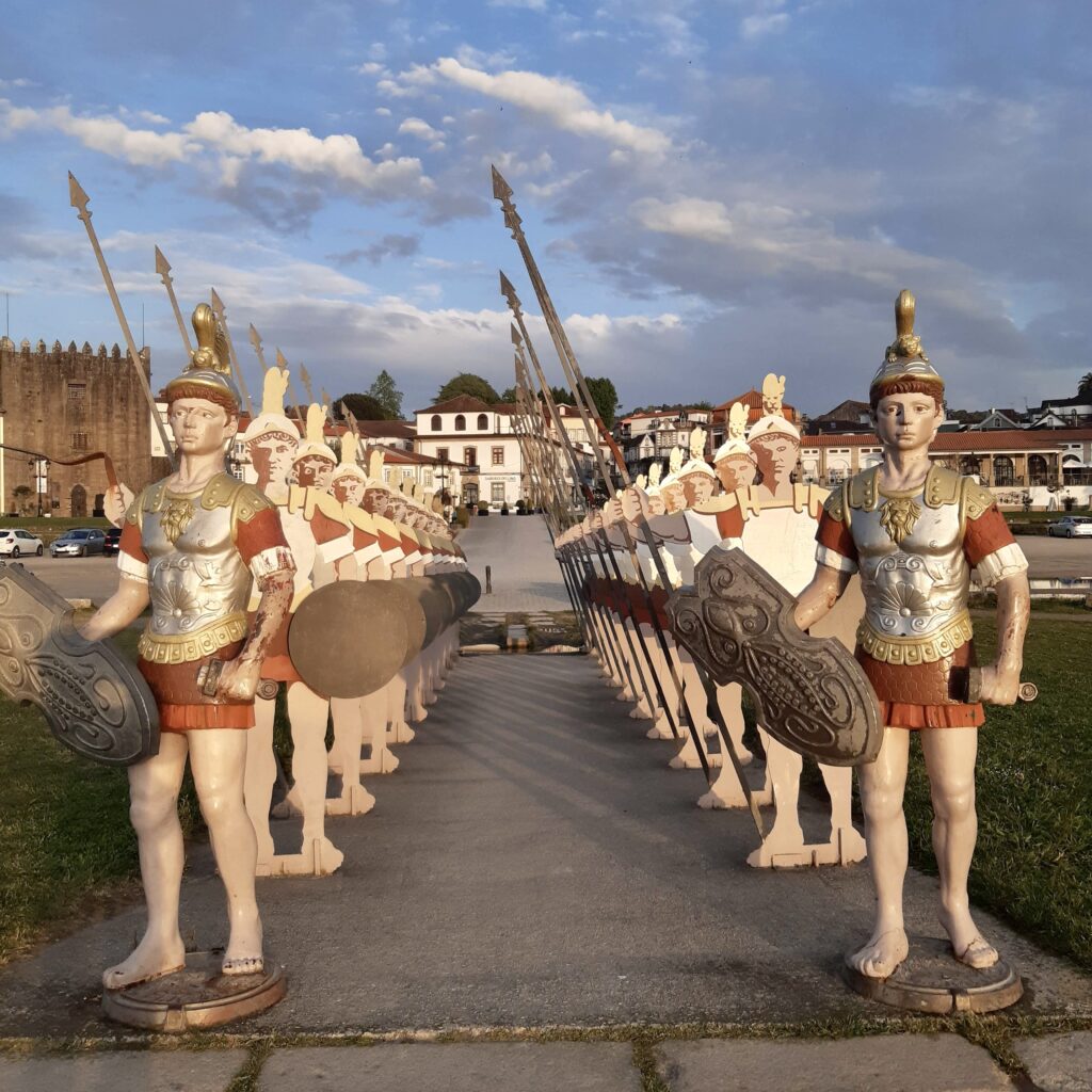 Statues of Roman soldiers on the river bank in Ponte de Lima in Portugal