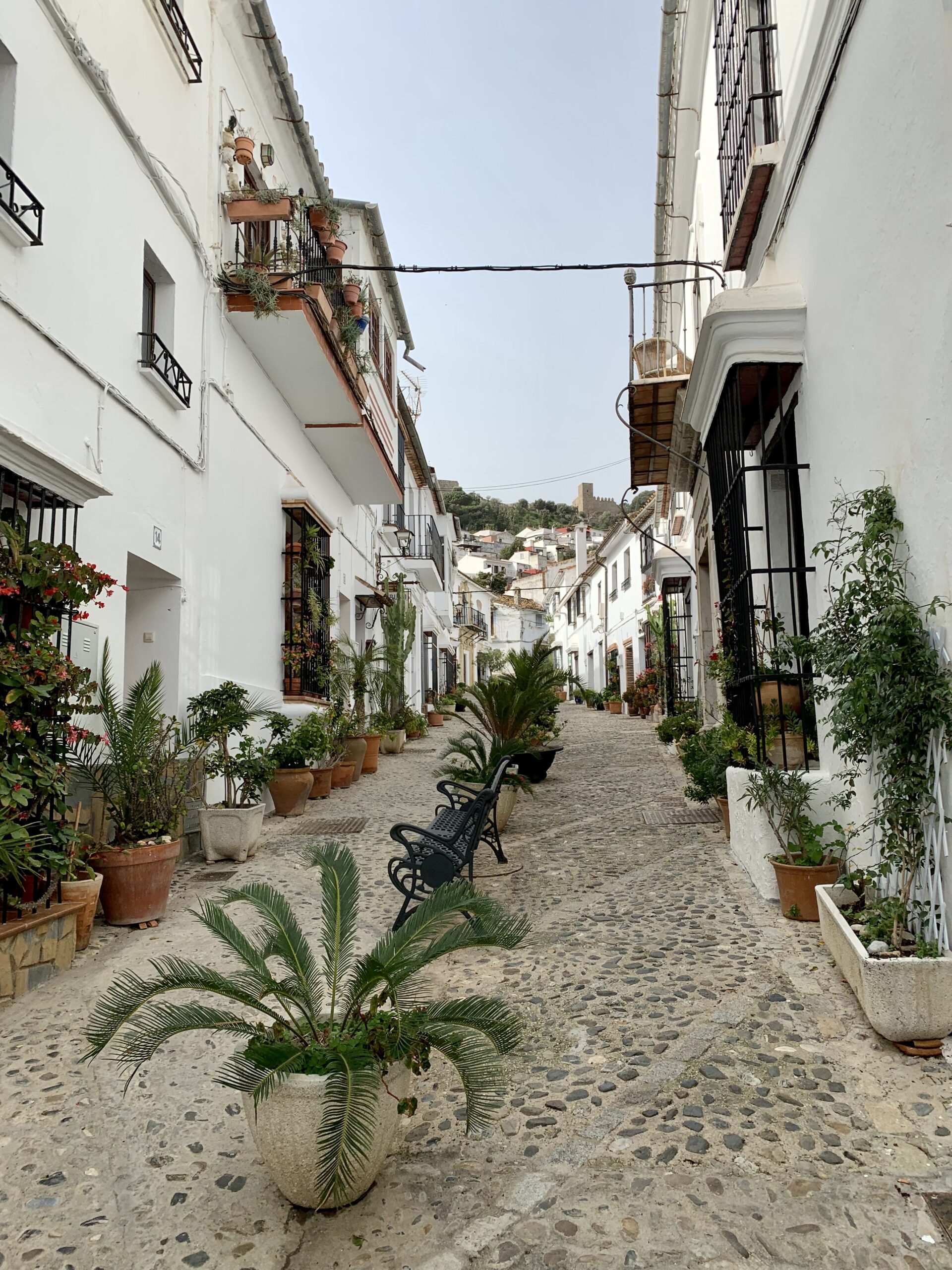 A view of one of the narrow streets in Jimena de la Frontera with the Moorish castle on the hilltop above