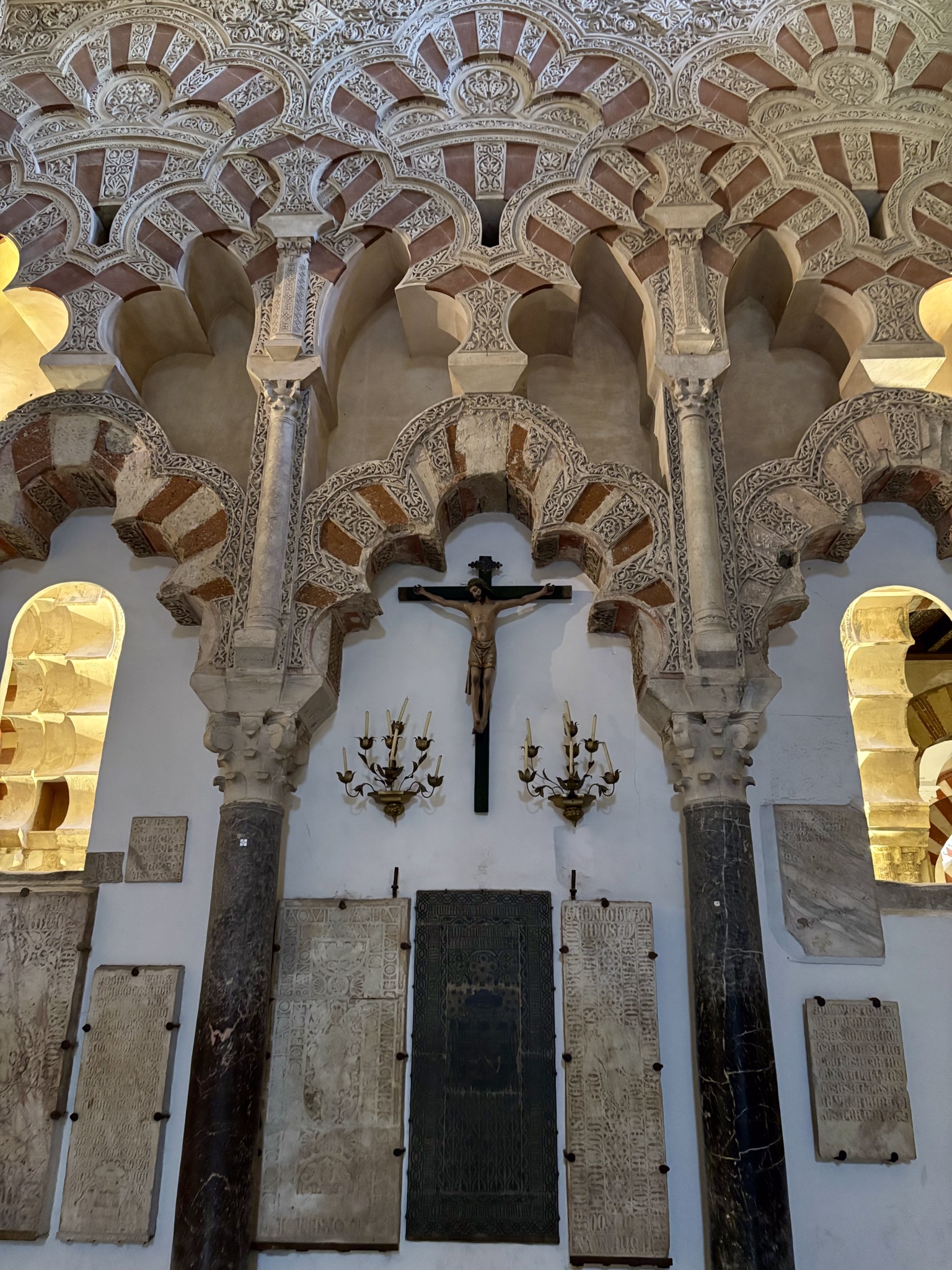 Interior arches of the Mezquita Córdoba Mosque-Cathedral above a statue of Jesus on the cross